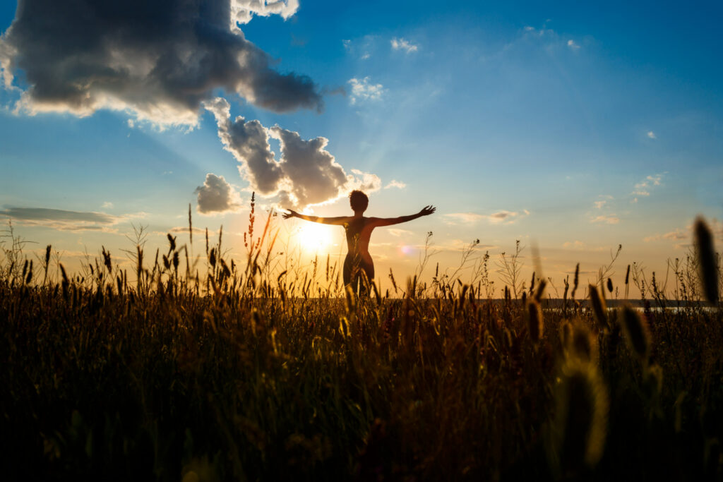 Mujer haciendo yoga mientras ve la puesta de sol